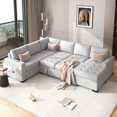 a living room with a sectional couch and pillows on the floor next to a large window