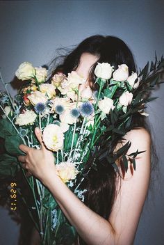 a woman holding flowers in front of her face