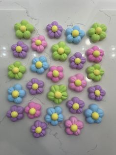 there are many different colored flowers on the counter top, including one with yellow and blue centers