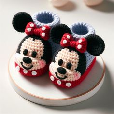 two crocheted mickey mouse shoes on top of a plate