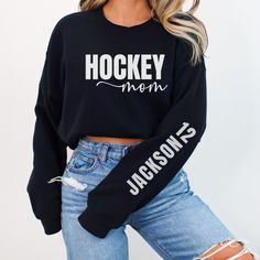 a woman wearing a hockey mom sweatshirt and ripped jeans with her hands in her pockets