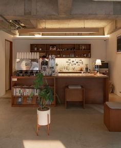 an open kitchen and dining area with bookshelves on the wall, potted plant in center