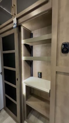 an empty pantry with shelves and refrigerator in it