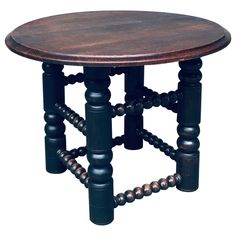 a small wooden table with metal beads on the legs and round wood top, against a white background