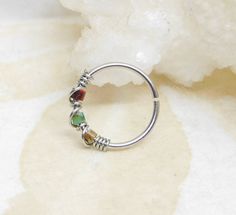 a silver ring with multi colored stones on it