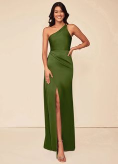 a woman in a green one shoulder dress with slits on the side and her legs crossed