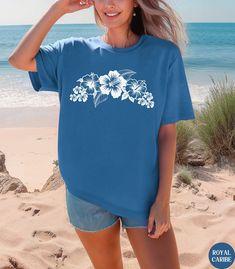 🌺🌸Discover our Tropical Hibiscus flower Comfort Colors unisex shirt This Hibiscus pattern t-shirt features an eye-catching white graphic design. Made of 100% ring-spun ethically grown cotton, this shirt is super soft and comfortable. It has a relaxed fit which is made of a medium fabric that is preshrunk. Looks super cute with shorts or jeans or size up 1-3 sizes for an oversized beach coverup. Great gift for a Beach Lover! Comes in 13 pretty colors! 💠PRINT: This is a handmade, Direct-to-Garm Beach Hawaiian Shirt With Floral Print And Short Sleeves, Floral Print Hawaiian Shirt For Beach, Short Sleeve Hawaiian Shirt With Floral Print For Beach, Beach Shirt With Hibiscus Print, Summer Vacation Hawaiian Shirt With Hibiscus Print, Blue Hawaiian Shirt With Hibiscus Print For Summer, Summer Hawaiian Shirt With Hibiscus Print For Vacation, Blue Hawaiian Shirt With Hibiscus Print For Beach, Hawaiian Shirt With Hibiscus Print For Beach Season