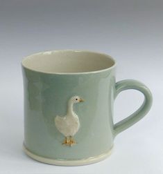 a ceramic mug with a duck painted on it