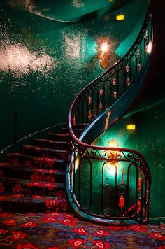 a spiral staircase next to a green wall