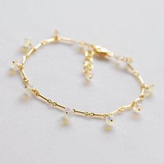 This delicate chain bracelet has a kind of gossamer look. It is designed with gold filled bar chain adorned with smooth polished roundels of milky Ethiopian opals with just a touch of fire . All of the gems are wrapped on gold filled ball head pins and dance around the length of the bracelet. 7.25 inches long with 1 inch extender, this bracelet closes with a lobster style clasp. Perfect layering bracelet, beautiful gift. I imagine it perfect for a bride. This style bracelet is available with pin Delicate Chain Bracelet With Extender, Gold Dainty Charm Bracelet With Extender, Minimalist Gold Pearl Bracelet With Delicate Chain, Delicate Hypoallergenic Gold Plated Bracelets, Adjustable Delicate Gold Bracelet With Chain, Gold Adjustable Chain Bracelet For Weddings, Dainty Gold Bracelet With Extender, Gold Wedding Bracelet With Adjustable Chain, Delicate Gold Bangle Bracelet