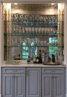 a bar with wine glasses and liquor bottles on the top shelf in front of it