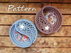 two crocheted baskets sitting on top of a wooden table