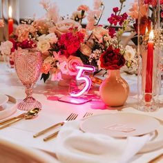 the table is set with flowers and candles