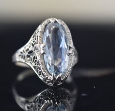 Light sky blue aquamarine shaped as an elongated oval. Set in a classic edwardian filigree lace setting. In excellent condition. Size 5.5, sizeable Oval Topaz Ring For Formal Occasions, Art Deco Blue Topaz Oval Jewelry, Blue Oval Topaz Ring In Art Deco Style, Oval Heirloom Topaz Ring For Formal Occasions, Classic Light Blue Oval Jewelry, Vintage Oval Filigree Ring With Diamond Cut, Formal Oval Hallmarked Topaz Ring, Formal Oval Topaz Ring Hallmarked, Heirloom Oval Topaz Ring Hallmarked