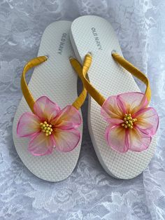 These beautiful white flip flops are hand wrapped in yellow satin ribbon, and adorned with a handmade two tone in pink and yellow organza flower with pistils in the center. N-116 Ribbon color is yellow, if you are needing other colors of ribbon or decoration please contact me and will be happy to accommodate you! All flip flops are handmade to order and the production time is 5-7 business days and then please allow additional time for shipping. Amazing for beach, weddings, flower girl or a fancy Pink Handmade Sandals For Party, Pink Party Flip Flops For Summer, Pink Summer Party Flip Flops, Summer Party Pink Flip Flops, Pink Party-style Summer Flip Flops, Adjustable Pink Sandals For Wedding, Pink Flower Sandals For Vacation, Pink Flower Sandals For Summer, Pink Flower-shaped Sandals For Summer