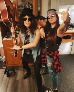 two women are posing for a photo in the kitchen with their guitars and hats on