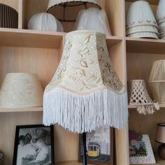 a lamp that is sitting on top of a book shelf next to pictures and other items