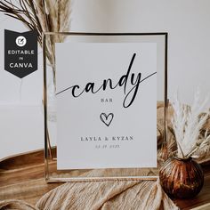 a candy bar sign sitting on top of a table next to a vase with dry grass