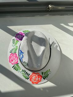 Beautiful Guatemalan hat with hand-painted flowers. The perfect accessory for any outfit! Hand Painted Brimmed Sun Hat For Spring, Artistic Fedora Sun Hat For Spring, Hand Painted Brimmed Hats For Spring, Hand Painted Curved Brim Sun Hat For Spring, Handmade White Fedora For Spring, Artistic Fedora Hat For Spring, Artisan Short Brim Hat For Spring, Hand Painted Sun Hat With Curved Brim For Spring, Spring Artistic Fedora Hat