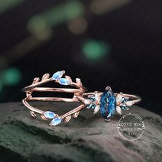 a close up of a ring on top of a rock with leaves and blue stones