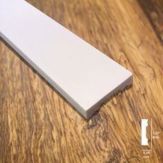 a close up of a white object on a wooden table with wood grained flooring