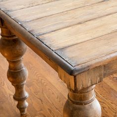 an old wooden table with wood grained floors and no one sitting at the top