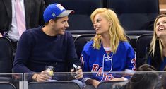 a man and woman sitting next to each other at a baseball game