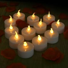 many lit candles are arranged in the shape of a heart