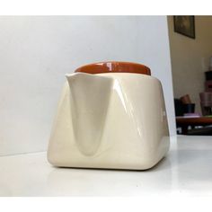 two ceramic vases sitting on top of a white counter next to each other in a room