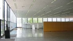 an empty room with lots of windows and white sculptures on the floor in front of it