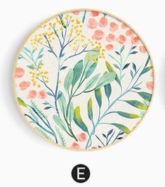 two plates with floral designs on them, one has an e and the other has flowers