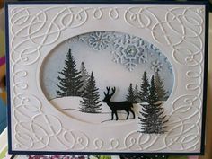 a christmas card with a deer and snowflakes in the background on a table