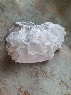 Beautiful all white baby frilly nappy/diaper cover.  This would look lovely worn with any little dress but especially for christenings or weddings, due to its traditional/vintage style. Made from 100% cotton material for the main cover with three rows of gorgeous delicate Nottingham Lace, giving the item a vintage/traditional look that never dates. The leg and waist cuffs are formed from super soft bias binding which encases the soft elastic. These are machine washable on a max 40 degree wash an White Cotton Bloomers With Ruffles, White Cotton Ruffled Bloomers, White Lace Ruffled Bottoms, Fitted White Cotton Diaper Cover, White Lace Ruffled Petticoat, White Ruffled Lace Petticoat, White Lace Petticoat With Ruffles, Fitted White Diaper Cover For First Birthday, Nottingham Lace