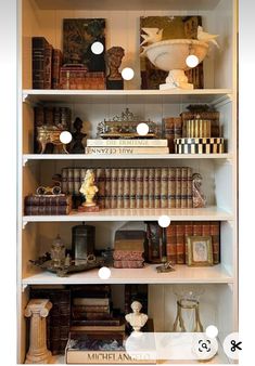 a book shelf filled with lots of books and figurines on top of it