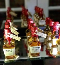 several bottles of liquor are lined up on a table with red ribbon around the top