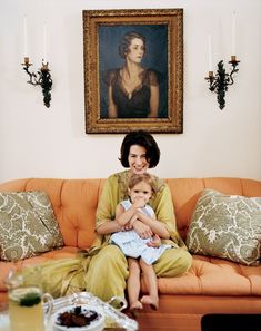 a woman sitting on top of a couch holding a child