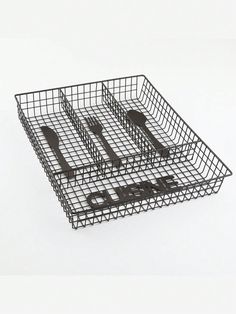 a metal basket with utensils and spoons in it on a white surface