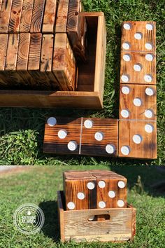 several pieces of wood sitting on top of the grass next to some dominos and boxes