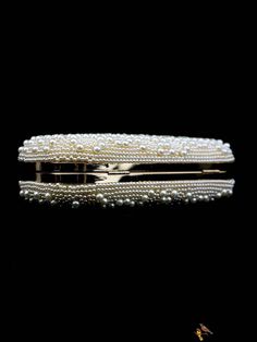 a gold and white beaded purse on a black surface