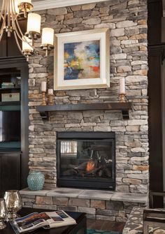 a living room with a fire place in the center and a painting on the wall