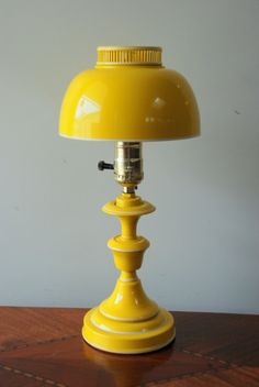 a yellow lamp sitting on top of a wooden table