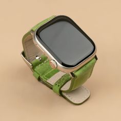 a smart watch sitting on top of a green strap