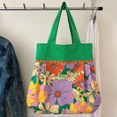 a purse hanging on a clothes rack next to a pair of jeans