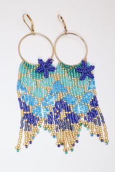 Have you heard the mermaids calling? Our new mermaid tail seed bead hoop earrings are calling to you too.  Add a touch of magic to your day with our hand beaded earrings in iridescent bright colors.  They feature starfish dangles and jeweled fins.  Made with premium delica seed beads and gold filled hoops & lever b Ocean-inspired Colorful Beads Jewelry, Beaded Dangle Beach Jewelry, Beaded Dangle Jewelry For The Beach, Summer Beaded Starfish Jewelry, Beaded Dangle Jewelry For Beach, Bohemian Jewelry With Starfish Charm For Festivals, Ocean-inspired Colorful Beads For Jewelry Making, Ocean-inspired Colorful Beaded Summer Jewelry, Summer Beach Hoop Earrings With Tiny Beads