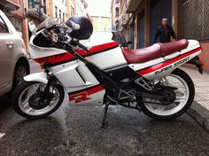 a white and red motorcycle parked on the street