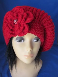 a mannequin head wearing a red knitted hat with flowers on the top