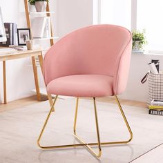 a pink chair sitting on top of a white rug next to a desk and window