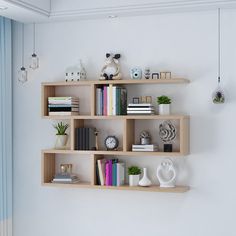 three wooden shelves on the wall with books and other items in them, one is empty