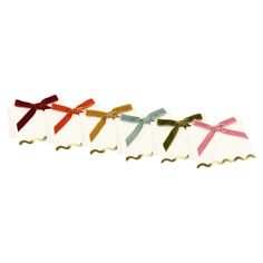 four small tags with bows on them are lined up in a row against a white background