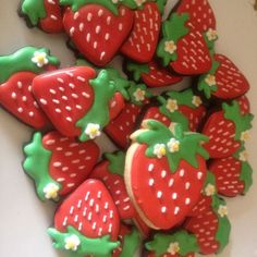 there are many decorated cookies in the shape of strawberries